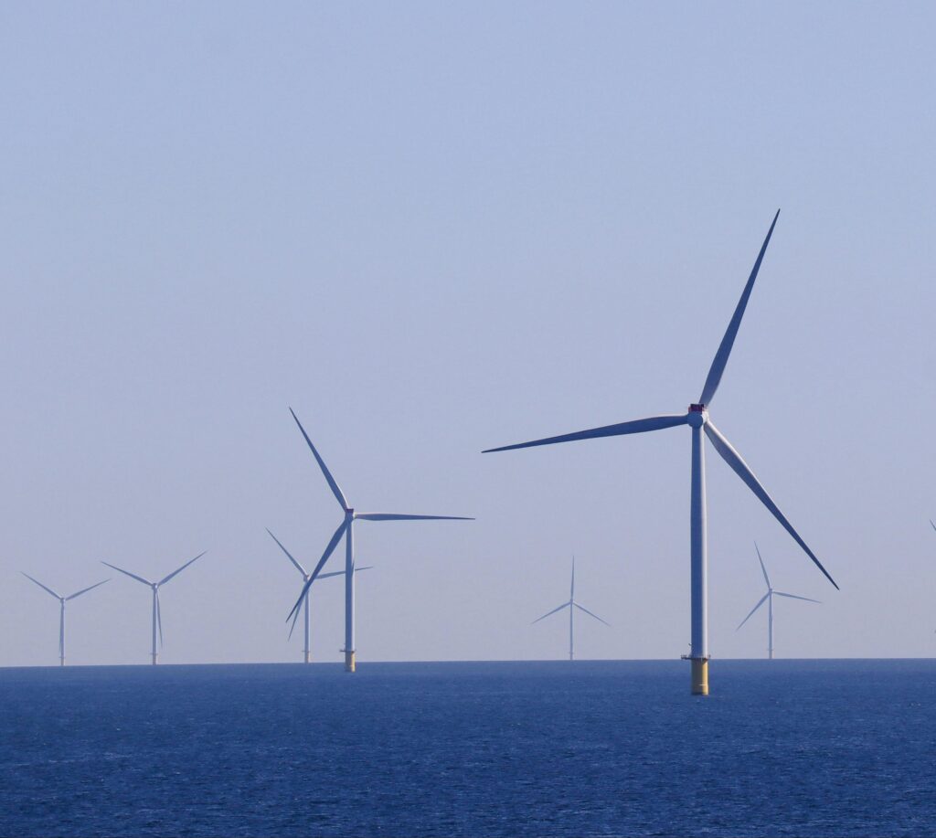 Wide view of offshore wind turbines generating renewable energy over the ocean.