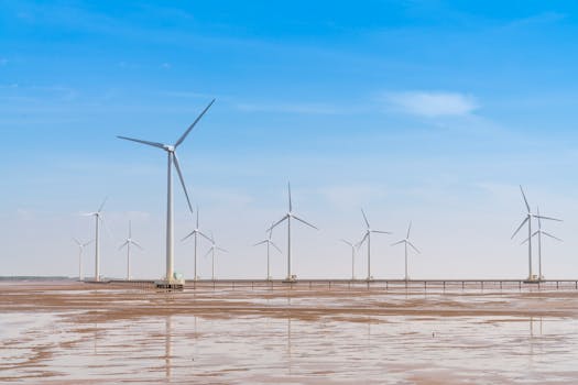 Expansive wind farm with turbines under a bright blue sky, showcasing renewable energy.