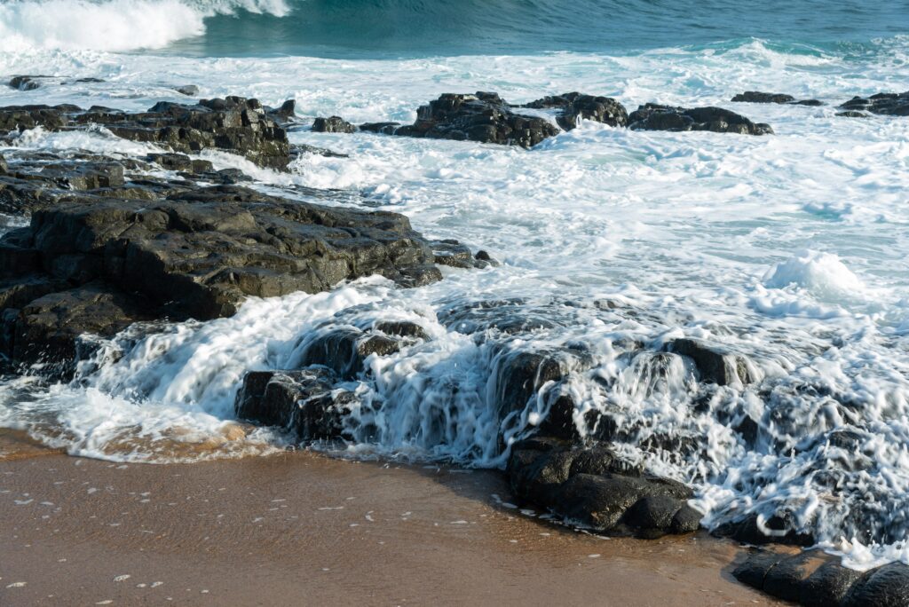 Dynamic seascape with waves crashing on rocky beach shore, showcasing nature's power.